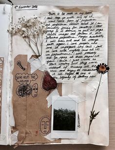 an open book with writing and flowers on it's cover, surrounded by papers