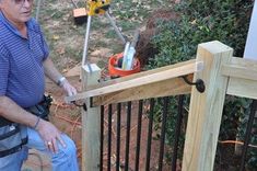 an older man sitting on top of a wooden fence