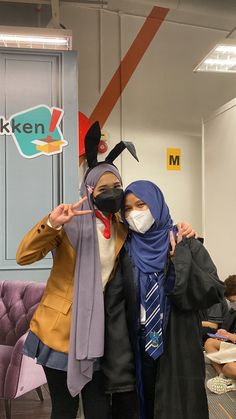 two people wearing masks standing next to each other