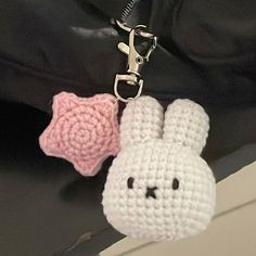 a crocheted bunny key chain with a pink rose on it's side