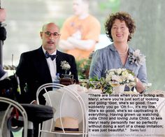 a man and woman sitting at a table with flowers in front of them on the screen