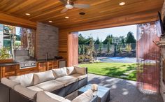 an outdoor living area with couches, table and grill