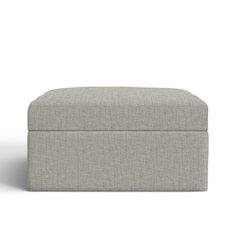 a grey ottoman sitting on top of a white floor