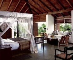 a bedroom with a canopy bed and two chairs