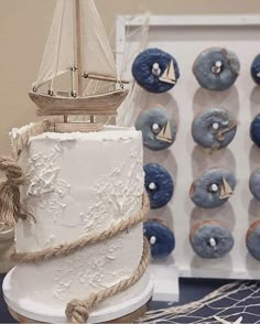 there is a white cake with blue frosting and a sailboat on top, along with other decorations