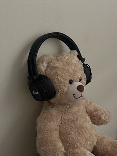 a teddy bear with headphones hanging on the wall