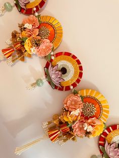 colorful paper flowers are arranged on top of each other with tassels attached to them