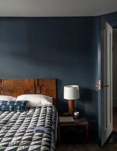 a bedroom with blue walls and a wooden headboard