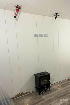 a room with white walls and wood flooring that has been taped to the wall