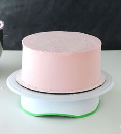 a pink cake sitting on top of a white plate