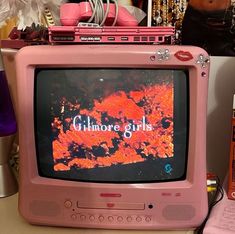 an old pink tv sitting on top of a desk