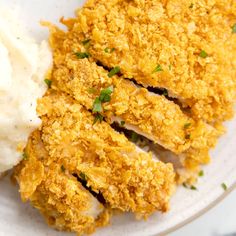 a white plate topped with fried chicken and mashed potatoes