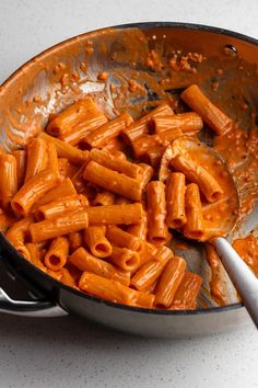 a pan filled with pasta and sauce on top of a table