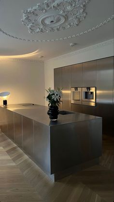 a modern kitchen with stainless steel appliances and wood flooring in the middle of it