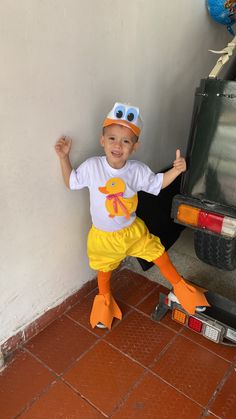 a little boy dressed up as a ducky on a skateboard in front of a truck