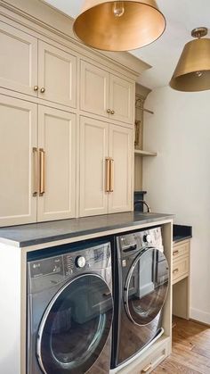 a washer and dryer in a room with cabinets