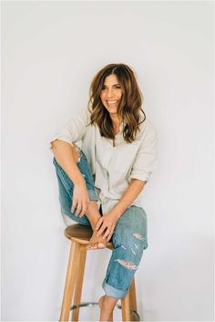 a woman sitting on top of a wooden stool