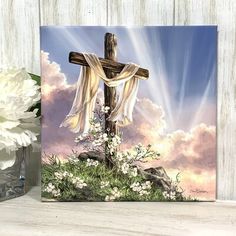 a painting of a cross with flowers and clouds in the background