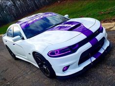 a white car with purple stripes parked on the street