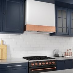 a stove top oven sitting inside of a kitchen next to blue cabinets and counter tops