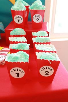 red and white cupcakes with green frosting on them sitting on a table