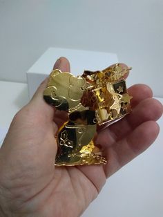 a person holding two pieces of gold in their hand