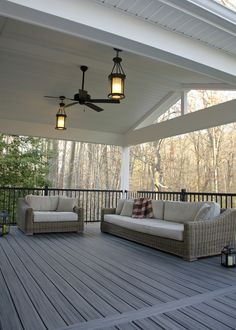 a porch with two couches and a ceiling fan