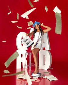 a woman standing on top of a chair in front of a red background with letters