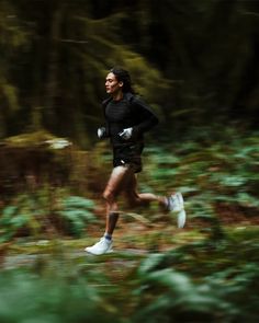 a man running in the woods on a trail