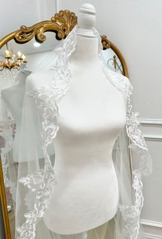 a mannequin with a veil on top of it in front of a mirror