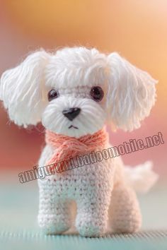 a small white dog with a scarf around it's neck sitting on a table