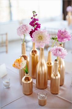 several vases with flowers in them sitting on a table