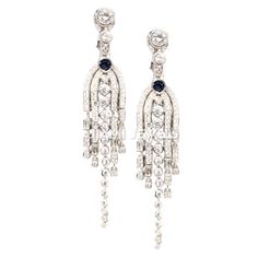 Enhance your elegance with these exquisite Blue Sapphire CZ Chandelier Tassel Drop Earrings. Crafted with attention to detail in 14k White Gold Finish 925 Sterling Silver, these English Lock Dangle earrings feature a unique design that is customized to perfection. The rich blue sapphire CZ stones add a touch of glamour, making them a statement piece for any occasion. these earrings are a stylish addition to any outfit. Materials: -925 Sterling Silver -Blue Sapphire CZ -CZ Diamond Care Instructio Classic Chandelier Dangle Earrings With 17 Jewels, Classic Long Drop Chandelier Earrings For Formal Occasions, Art Deco Dangle Chandelier Earrings For Formal Occasions, Formal Long Drop Chandelier Earrings, Formal Art Deco Dangle Chandelier Earrings, Formal Diamond Cut Dangle Chandelier Earrings, Elegant White Gold Dangle Chandelier Earrings, Elegant White Gold Chandelier Earrings, Exquisite Dangle Chandelier Earrings For Evening