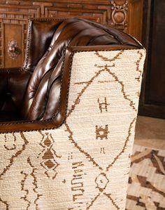 a brown leather chair sitting on top of a rug