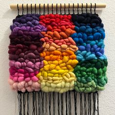 a multicolored piece of yarn hanging on a wall