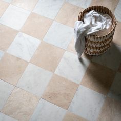 a basket that is sitting on the floor next to a towel and some cloths