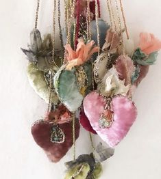 a bunch of heart shaped ornaments hanging on a wall