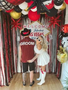 a man and woman standing in front of a welcome sign at a vegas themed party