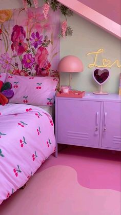 a bedroom with pink furniture and flowers painted on the wall above it, along with a heart shaped neon sign