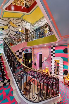 the stairs are decorated with multicolored wallpaper and chandeliers in this room