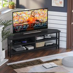 a flat screen tv sitting on top of a wooden stand