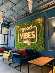 a restaurant with blue walls and green plants on the wall above it that says good vibes only