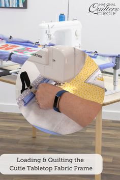 a person is using a sewing machine to sew fabric on the table with text reading loading & quilting the cute tabletop fabric frame