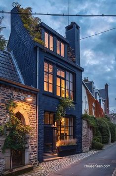 an old brick house is lit up at night with the lights on and windows open