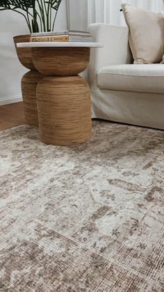 a white couch sitting next to a table on top of a rug