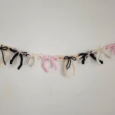 a white and black string with pink bows hanging from it