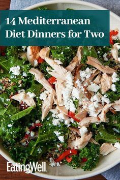 a white bowl filled with greens and chicken next to a blue napkin on top of a wooden table