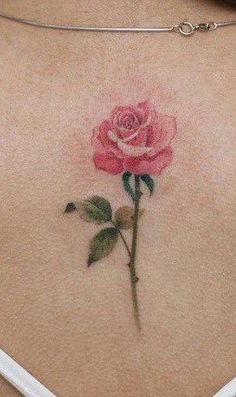 a rose tattoo on the back of a woman's stomach is shown in this image