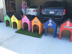 there is a woman standing in the garage next to some dog houses that are made out of cardboard