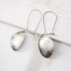 Simple and striking, these abstract titanium dangle earrings are sure to be a timeless favorite. Crafted from pure grade 1 titanium, these earrings are nickel-free and hypoallergenic, making them gentle on even the most sensitive ears. The lightweight and comfortable design is complemented by a subtle hammered silver texture, which creates an elegant surface that shines brilliantly in the light. Custom-made latching kidney wire hooks ensure a secure fit. Because these earrings are handmade, ther Modern Silver Hypoallergenic Linear Earrings, Hand Forged Drop Earrings For Gift, Hand-forged Drop Earrings For Gift, Modern Hypoallergenic Silver Linear Earrings, Modern Nickel-free Sterling Silver Teardrop Earrings, Modern Hand Forged Earrings For Gift, Hand Forged Long Drop Modern Earrings, Modern Hammered Linear Earrings For Gift, Modern Hammered Linear Earrings As Gift